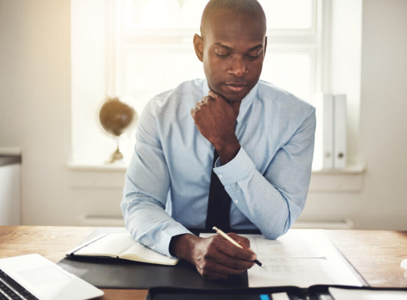 Young executive reading through paperwork at his desk